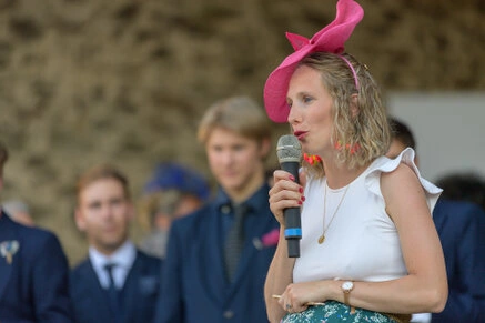 Invitée avec un micro prononçant un discours lors d’un mariage en extérieur
