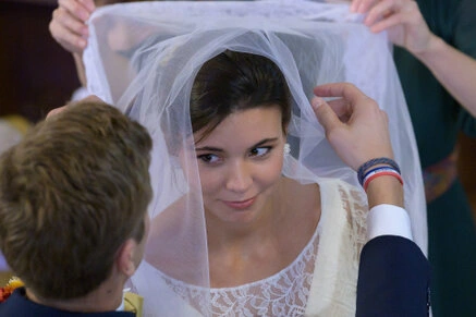 Le voile de la mariée est relevé pendant la cérémonie, révélant son visage dans un moment symbolique