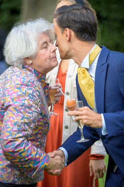 Marié embrassant une invitée âgée lors d’un moment émouvant pendant un mariage