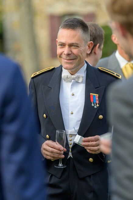 Invité en uniforme avec décorations lors du vin d’honneur d’un mariage en extérieur
