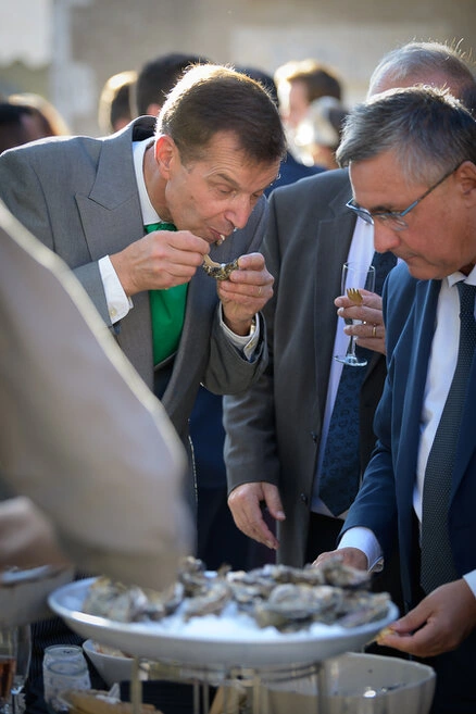 Invités dégustant des huîtres pendant le vin d’honneur d’un mariage en extérieur