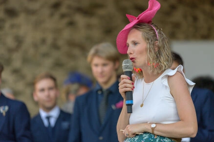 Invitée avec un micro prononçant un discours lors d’un mariage en extérieur