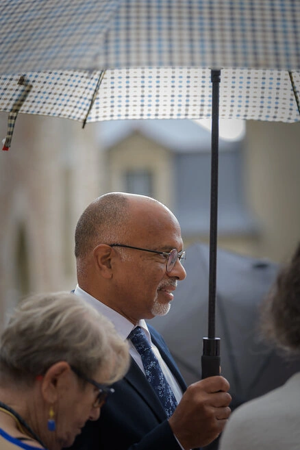Invité tenant un parapluie pendant un mariage, scène naturelle en extérieur