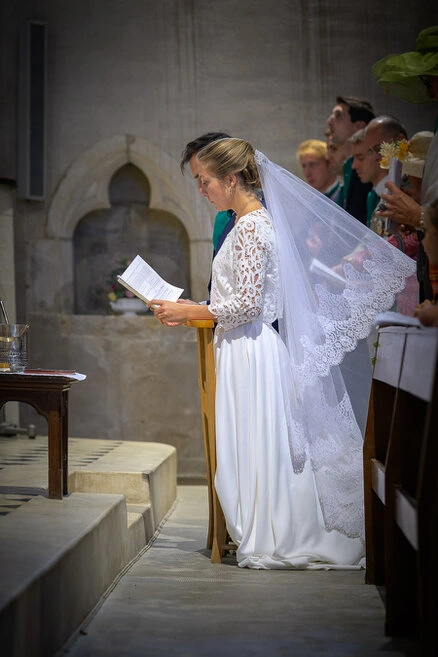 La mariée lit un texte pendant la cérémonie de mariage à l’église, moment solennel et attentif