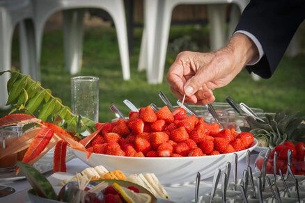 Buffet de mariage avec fraises fraîches et pièces cocktail lors du vin d’honneur en extérieur