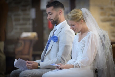 Les mariés assis lisent des textes pendant la cérémonie de mariage, moment calme et recueilli