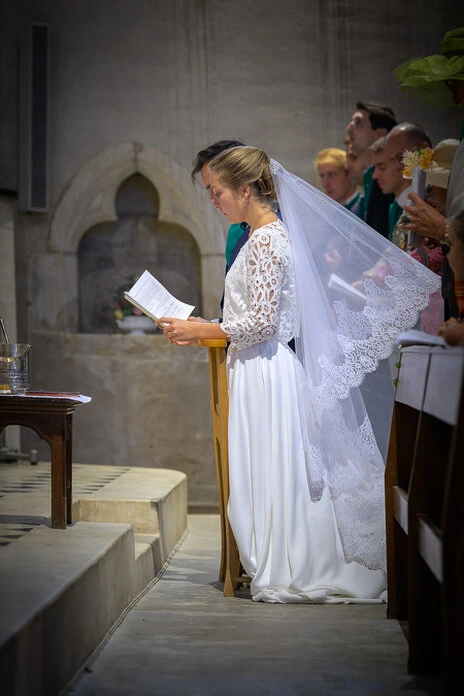 La mariée lit un texte pendant la cérémonie de mariage à l’église, moment solennel et attentif