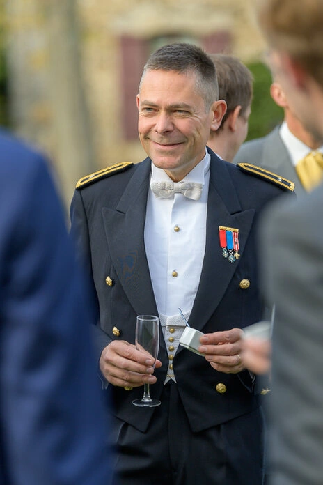 Invité en uniforme avec décorations lors du vin d’honneur d’un mariage en extérieur