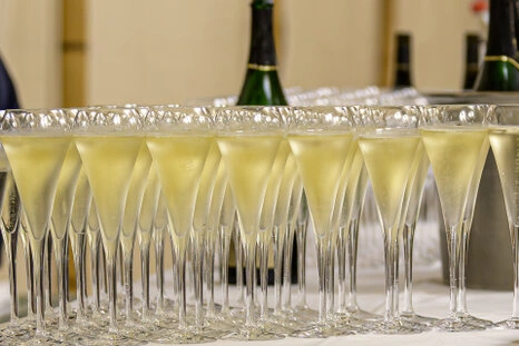 Rangée de coupes de champagne préparées pour un cocktail lors d’un événement professionnel