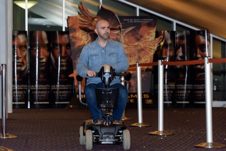 Homme se déplaçant sur un dispositif motorisé dans un espace d’accueil lors d’un événement professionnel
