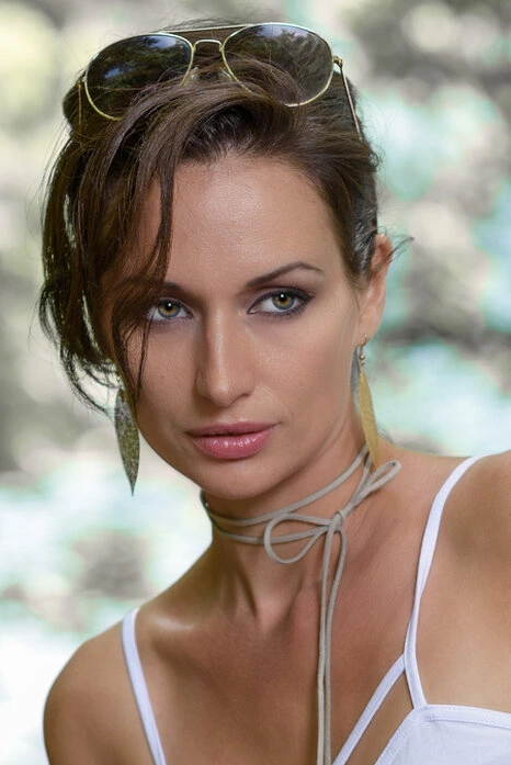 Portrait rapproché d’une femme avec regard direct, expression marquée et lumière naturelle mettant en valeur les détails du visage