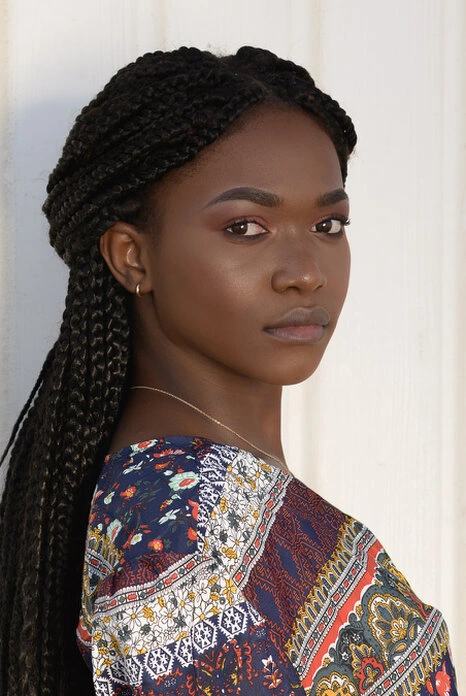 Portrait d’une femme avec regard direct et expression calme, éclairée par une lumière naturelle douce mettant en valeur le visage