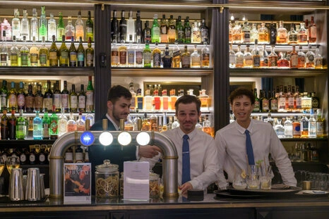 Portrait de plusieurs personnes travaillant ensemble derrière un comptoir, dans un environnement professionnel avec une ambiance conviviale