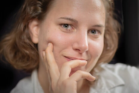 Gros plan sur le visage d’une femme avec une expression douce et naturelle, regard direct et lumière délicate