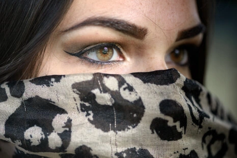 Gros plan sur les yeux d’une femme avec maquillage eyeliner et foulard, regard intense