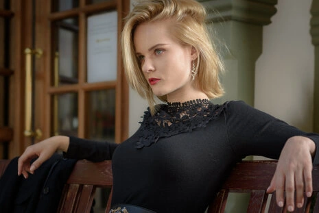 Portrait d’une femme élégante en intérieur portant une robe noire, regard posé et lumière douce