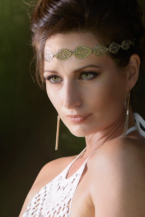 Portrait d’une femme avec accessoires et regard intense, éclairée par une lumière naturelle directionnelle mettant en valeur les traits du visage