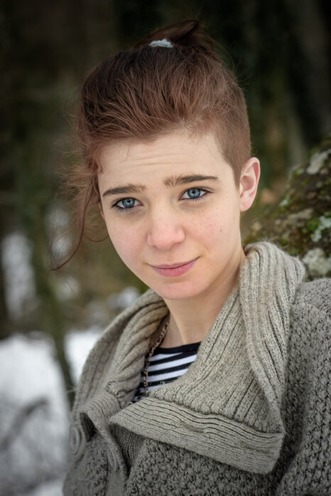 Portrait d’une femme en extérieur en hiver, regard direct vers l’objectif, lumière douce et ambiance naturelle