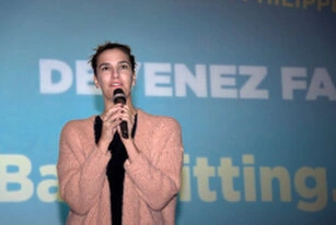 Femme intervenant sur scène avec un micro lors d’une conférence ou présentation en entreprise
