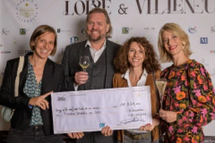Groupe de professionnels posant lors d’une remise de chèque pendant un événement d’entreprise avec cocktail