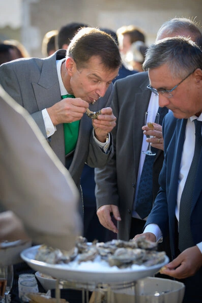 Invités dégustant des huîtres pendant le vin d’honneur d’un mariage en extérieur
