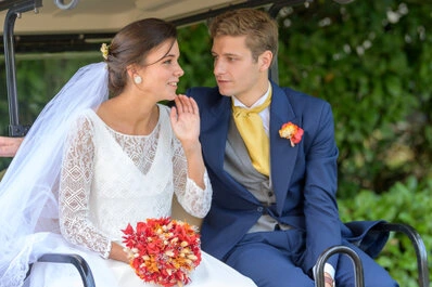 Couple de mariés échangeant un moment complice assis dans une voiture lors d’un mariage