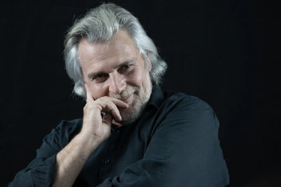 Portrait d’un homme en studio avec éclairage doux sur fond sombre, regard expressif et posture naturelle