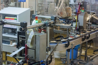 Ligne de production automatisée avec convoyeur et machines en fonctionnement dans un atelier industriel