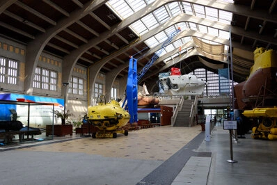 Salle d’exposition avec des engins techniques et une architecture intérieure lumineuse de grande hauteur